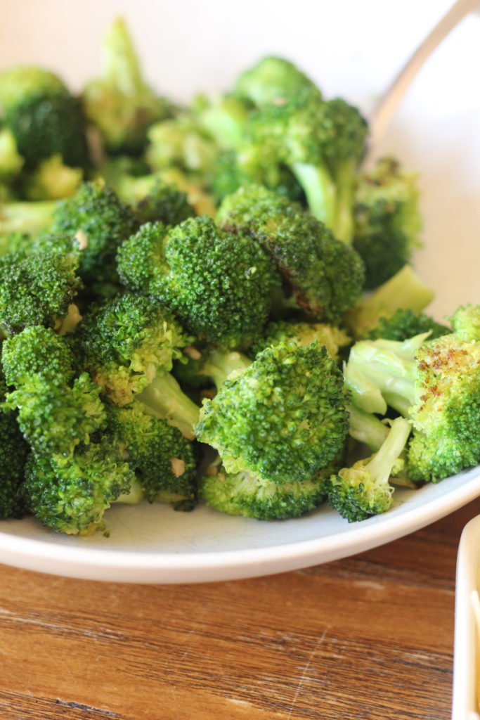 Garlic Butter Broccoli is the side dish that will go good with anything!! Make extra, this often doesn't make it to the table! #broccoli #sidedish #garlic broccoli cooked with butter and garlic in a white bowl