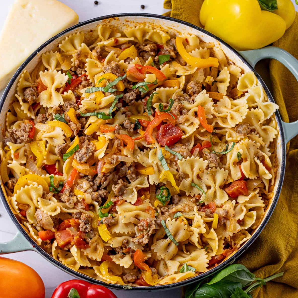 big skillet with bowtie pasta, peppers and sausage