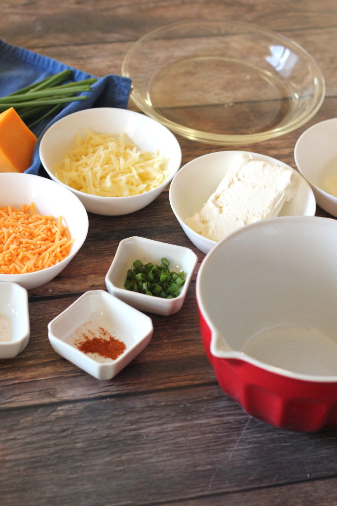 Bowls with two kinds of cheese, green onions, cayenne and cream cheese. 