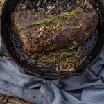 black cast iron pan with a tri tip cooked in it