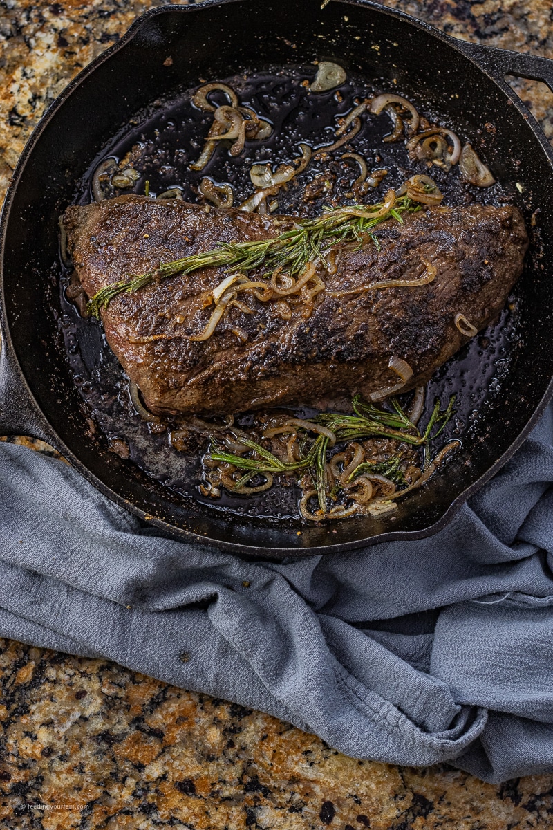black cast iron pan with a tri tip cooked in it