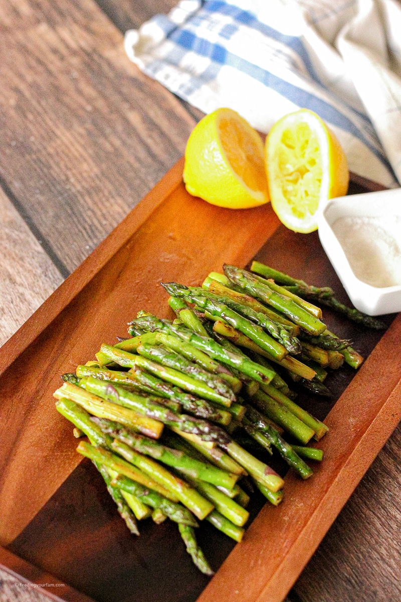 sliced, cooked asparagus on a wooden platter