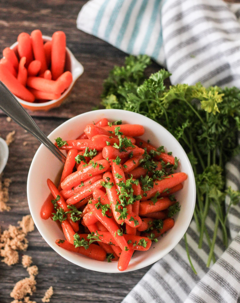 Cooked carrots are a delicious and super easy side dish to serve at your holiday dinner or just any night of the week! #glazedcarrots #cookedcarrots Cooked carrots glazed with brown sugar, butter and mustard with parsley garnish.