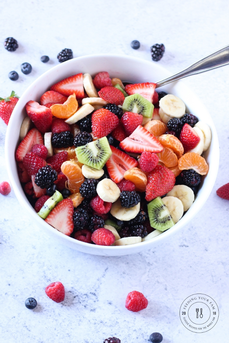 This summer fruit salad is stuffed with berry goodness and perfectly complimented with an orange ginger dressing! Perfect for all those summer potluck get togethers! You will have no leftovers when you bring this fruit salad to the table! #fruitsalad #berrysalad #mothersday #brunch Fruit salad