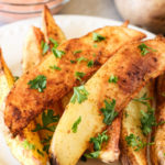 air fried potato wedges on a plate with greek yogurt dipping sauce
