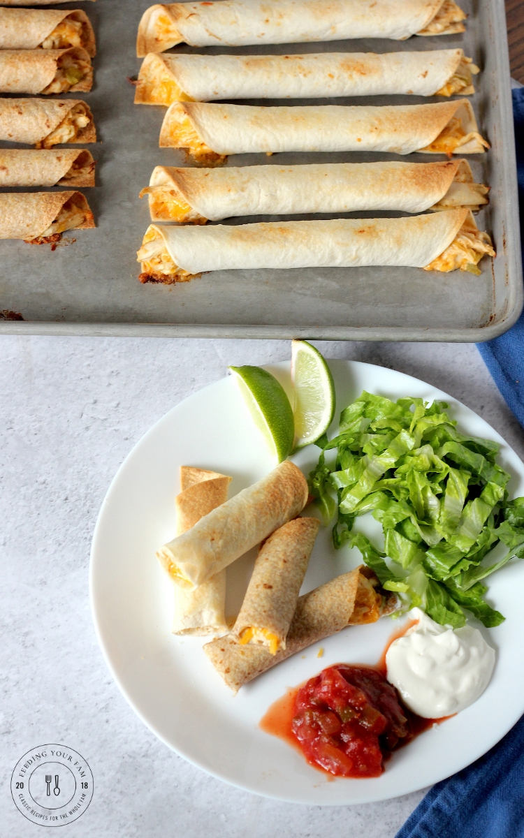 Crispy oven baked chicken taquitos served on a plate with salsa and sour cream
