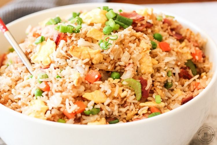 Bacon Fried Rice is a simple go to dish that is full of vegetables, rice and of course bacon! This is a staple recipe around our house, we usually have all of these ingredients on hand and this can be made quick. Dinner win!! bowl of fried rice