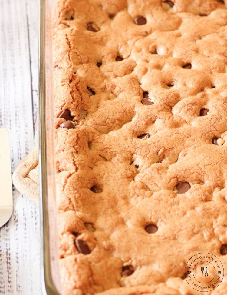 These Thick and Chewy Chocolate Chip Cookie Bars are rich, buttery and delicious!! Perfect for slicing and sharing, eating with a scoop of ice cream or packing for lunch! #cookiebars #chocolatechipcookies #chocolatechipbars chocolate chip cookie in a glass pan