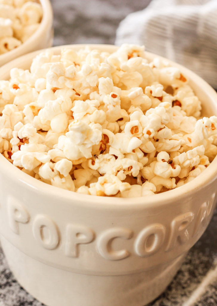 Kettle Corn is a sweet and salty treat that is super easy to make with just a few simple ingredients!! You are going to love this when it is fresh and warm off the stovetop! #kettlecorn #popcorn #foodgifts bowls of kettle popcorn