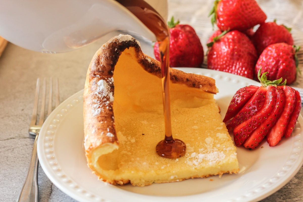 pouring syrup on a german pancake