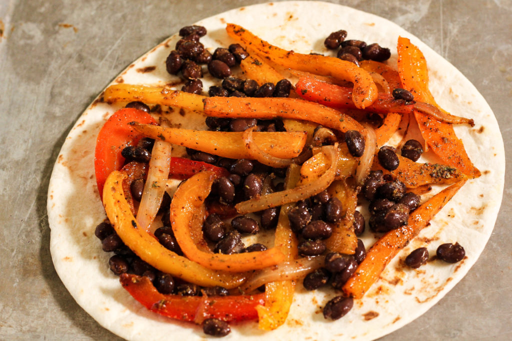 peppers and black beans on a tortilla to make quesadillas