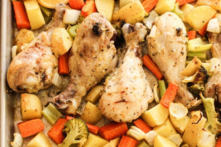 lemon chicken drumsticks with veggies on a sheet pan