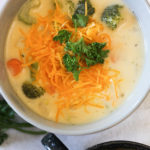 broccoli and potato cheese soup topped with cheese and parsley