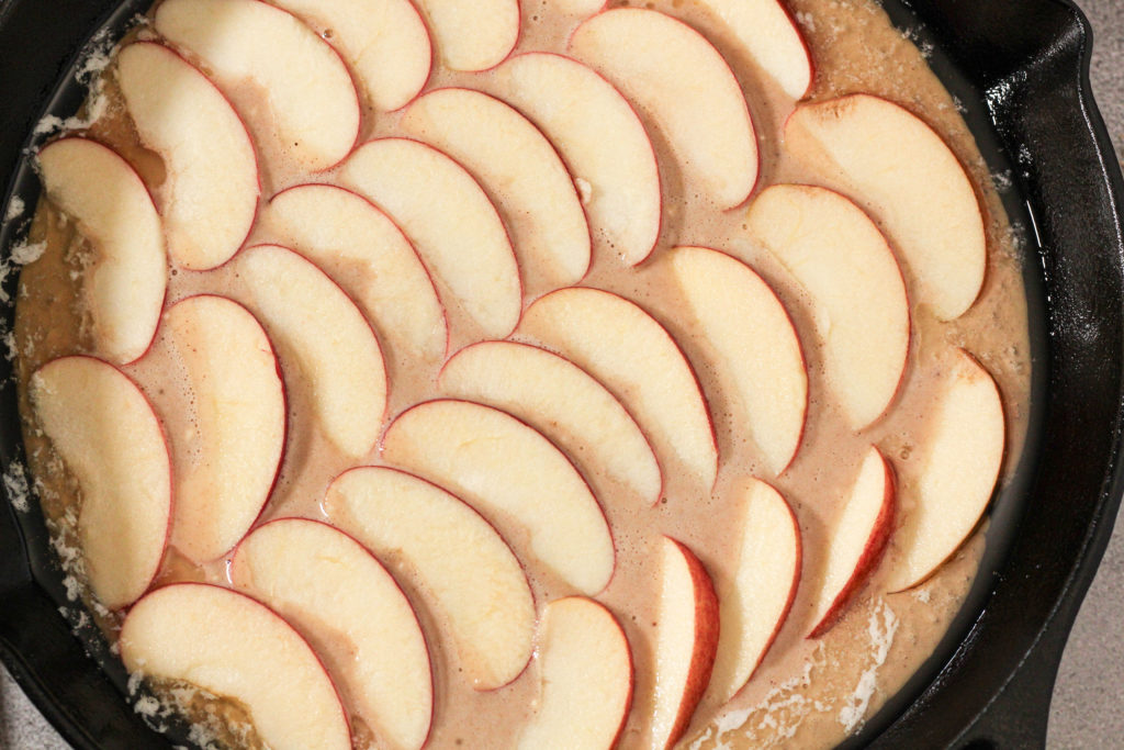german apple pancake batter in a cast iron skillet