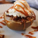 baked pear topped with ice cream and caramel