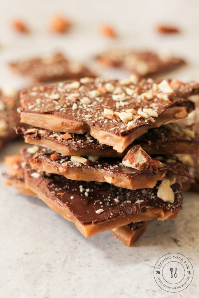 pile of english toffee topped with chocolate and chopped nuts