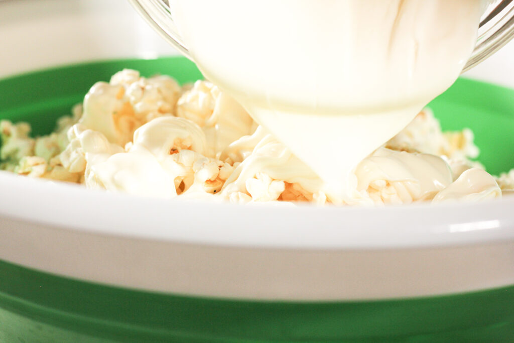 pouring white chocolate on popcorn