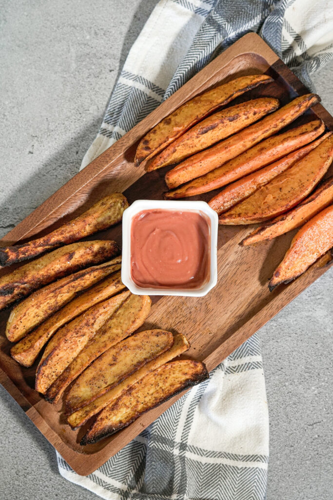 sweet potato wedges on a wooden serving platter