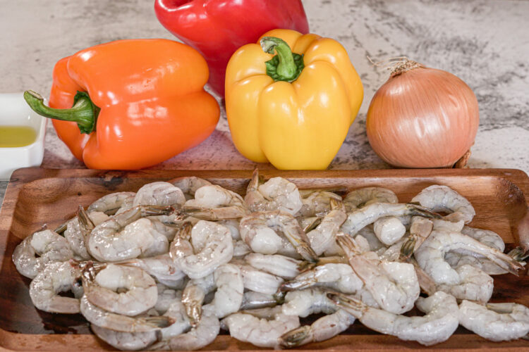 raw shrimp, peppers and an onion