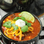 8 can taco soup topped with sour cream and cheese