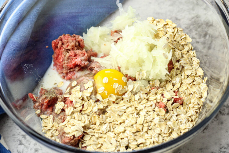ingredients for meatballs in a glass bowl
