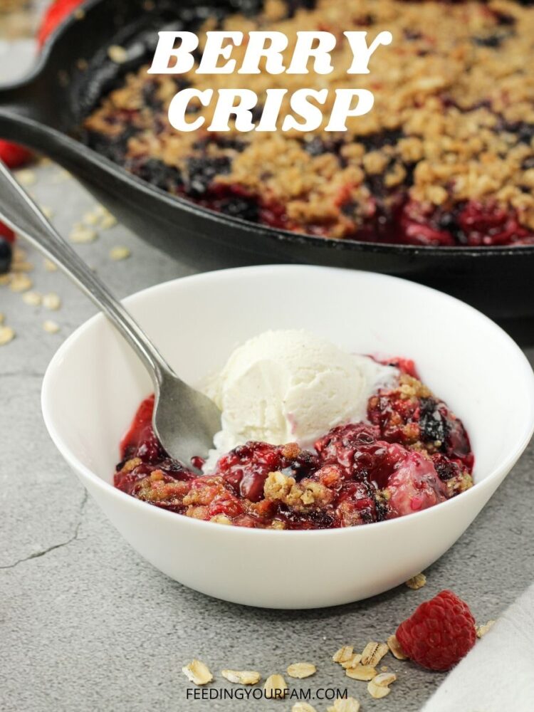 This Berry Crisp Recipe is a simple, refreshing fruit dessert. Packed with strawberries, raspberries and blueberries this triple berry crisp is a special treat! You are going to love how easy this treat is to make; you can feed the whole fam with one pan and everyone always loves this dessert. berry crumble in a white bowl with a scoop of vanilla ice cream