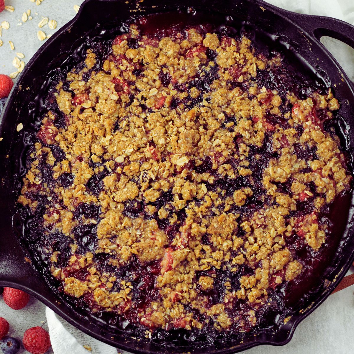 triple berry crisp baked in a cast iron skillet