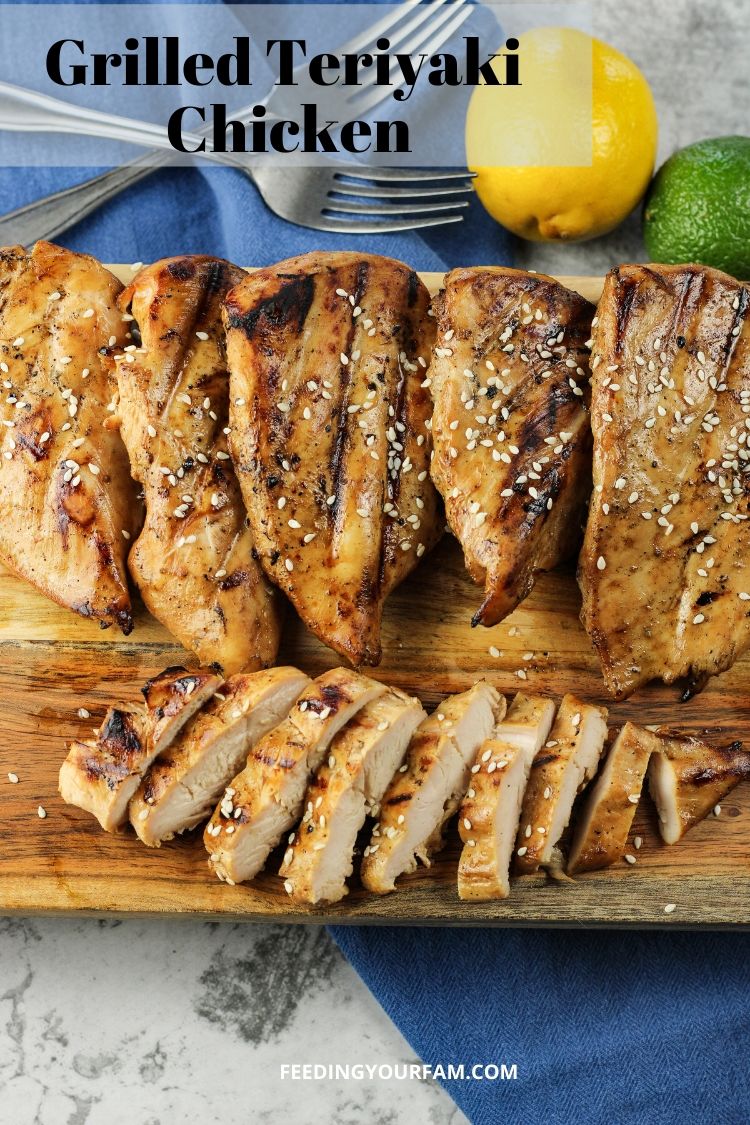 3 ingredient grilled teriyaki chicken. grilled chicken on a wooden cutting board. One chicken breast is sliced