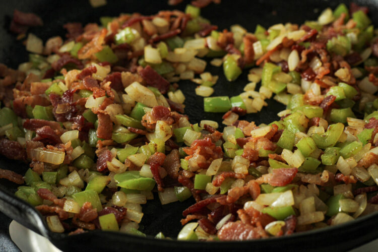 cooked bacon, onion and green pepper in a cast iron pan
