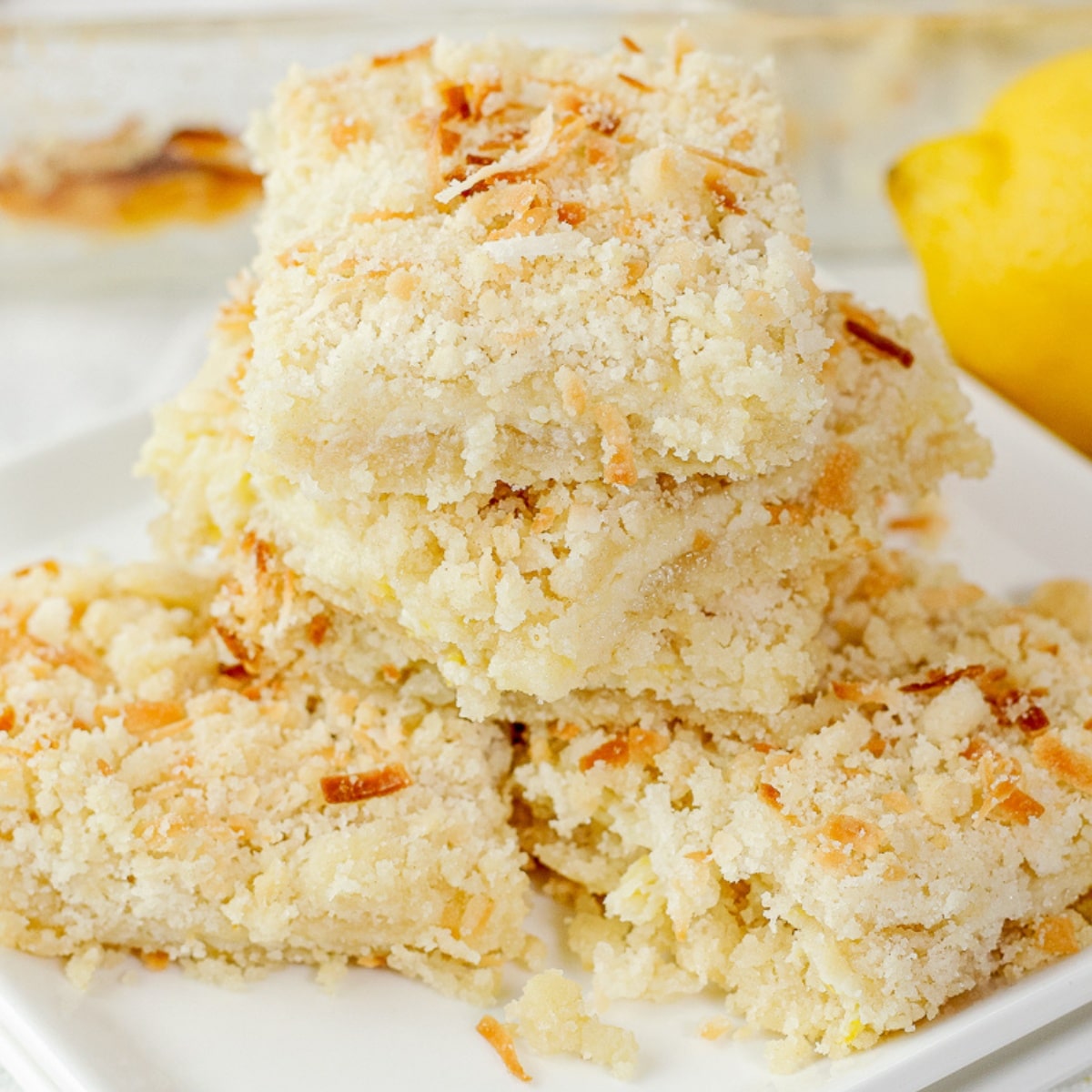lemon bars made with coconut on a white plate