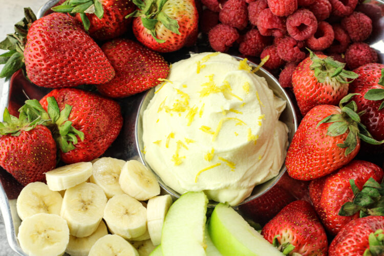 bananas, strawberries, raspberries and green apples surrounding yellow lemon fruit dip in the center