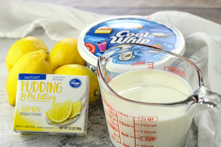 lemons, lemon pudding box, cool whip, milk in a measuring cup. Ingredients for lemon pudding dip
