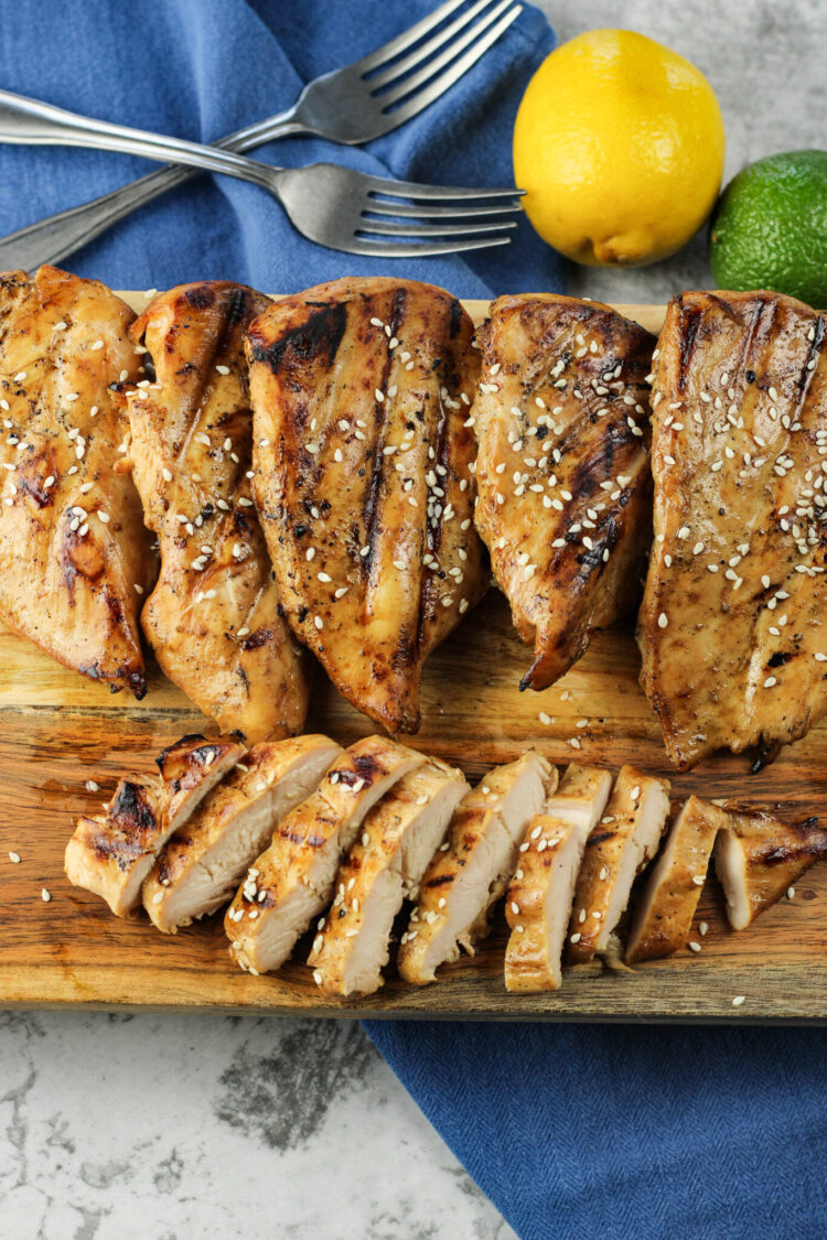chicken breasts, one sliced on a wooden platter