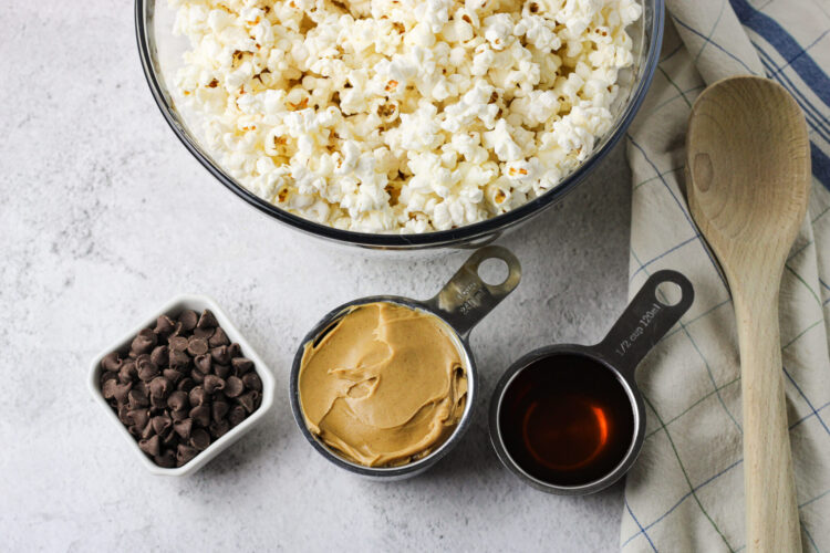 peanut butter and honey in metal measuring spoons. Also chocolate chips and popped popcorn in bowls