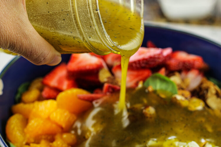 pour salad dressing on spinach salad