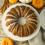 pumpkin bundt cake surrounded by small pumpkins