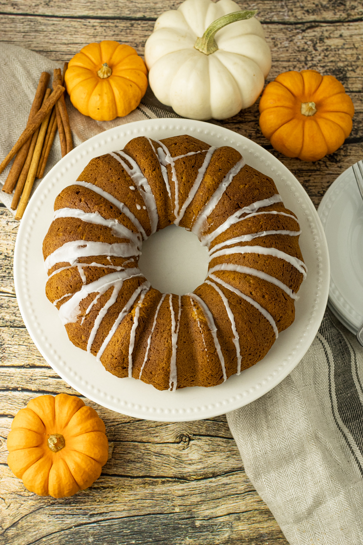 pumpkin bundt cake surrounded by small pumpkins