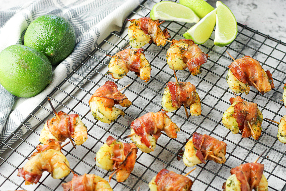 shrimp wrapped in bacon, seasoned with lime on a cooling rack