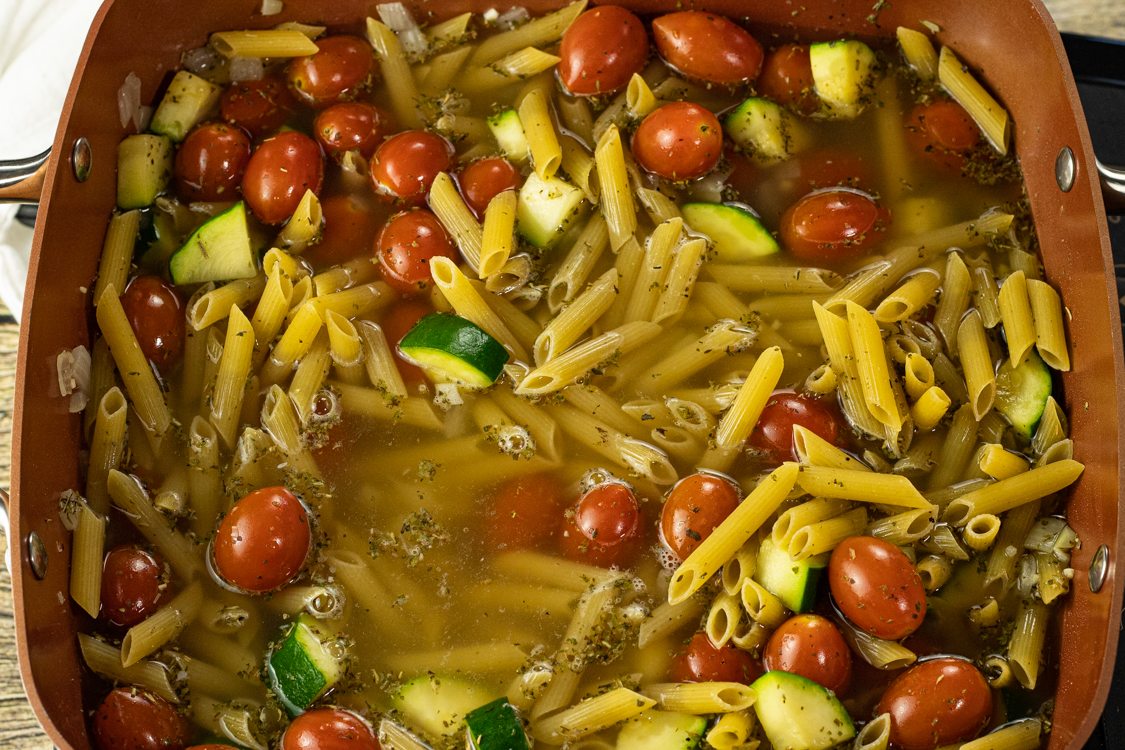 one pan pasta dish with tomatoes, zucchini and chicken broth