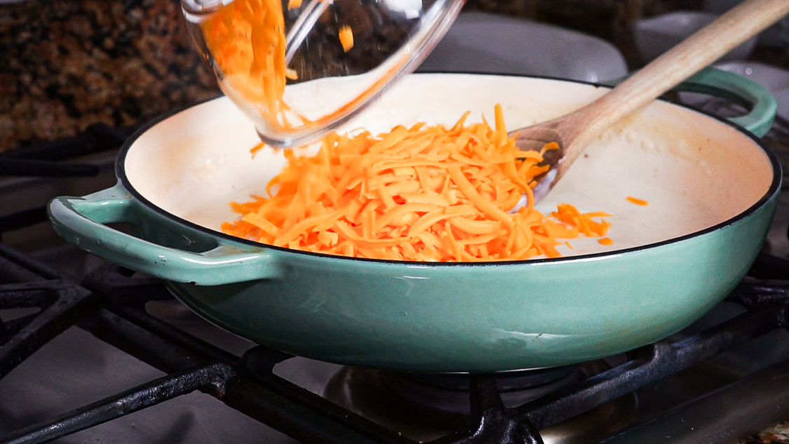 pouring cheese into pan with roux