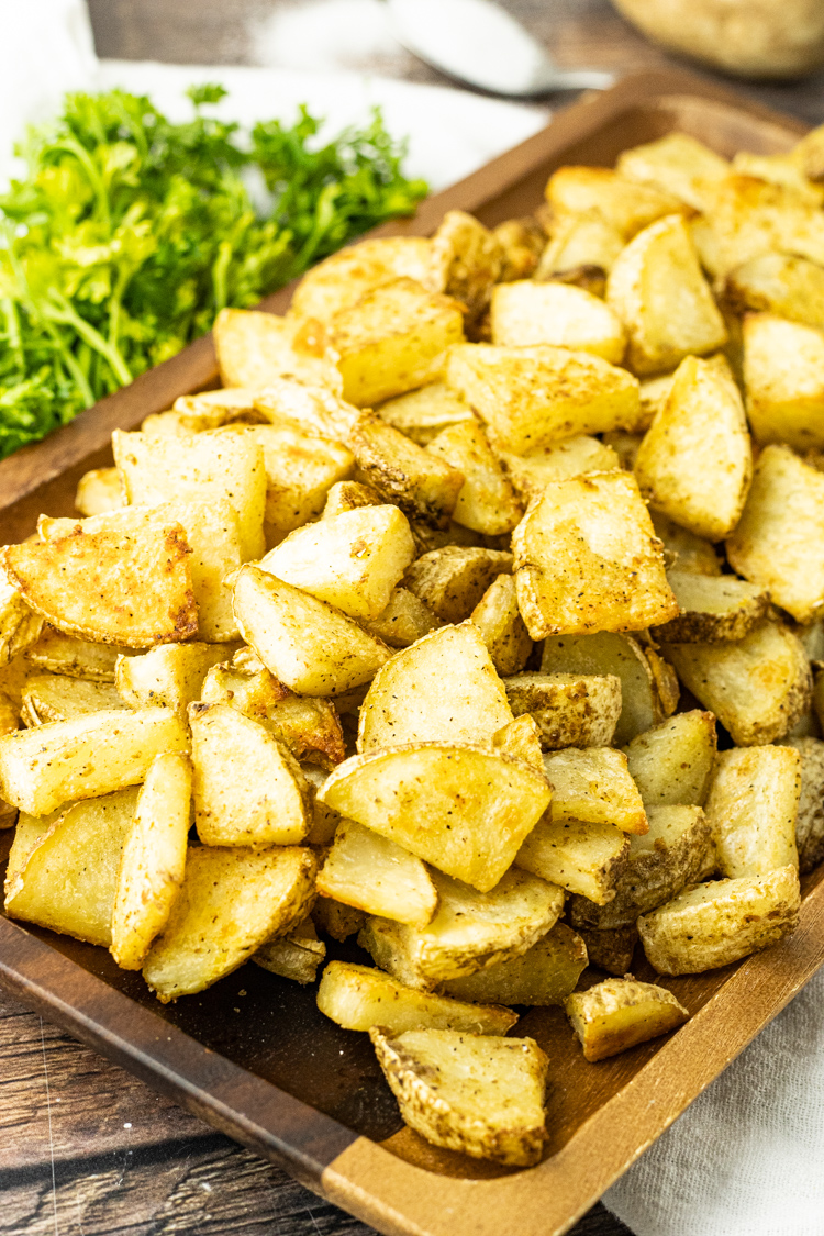 crispy potato slices on a wooden platter