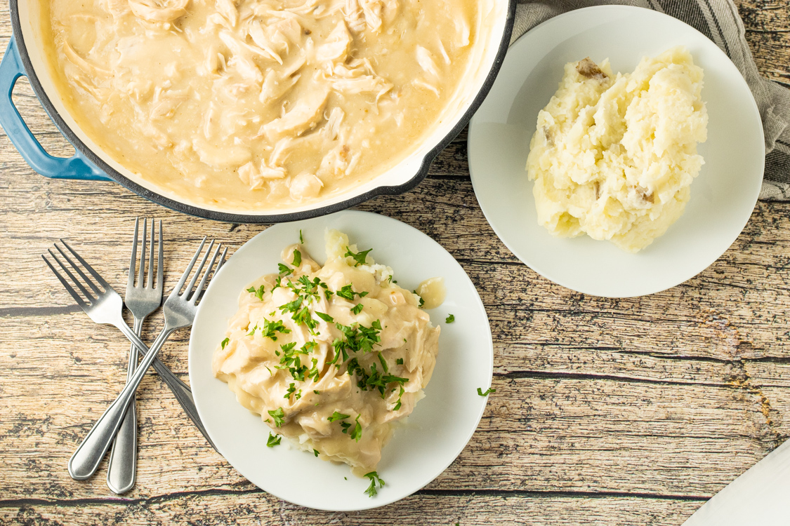 pot of chicken gravy and plates of mashed potatoes
