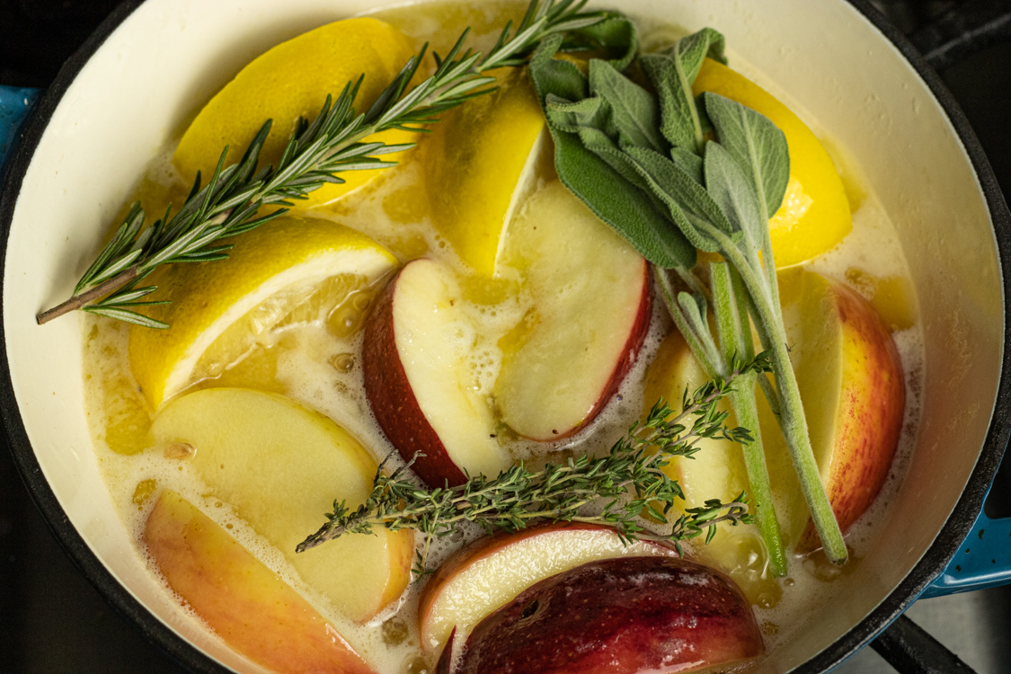 pan of butter, apples, lemons, rosemary, sage and thyme