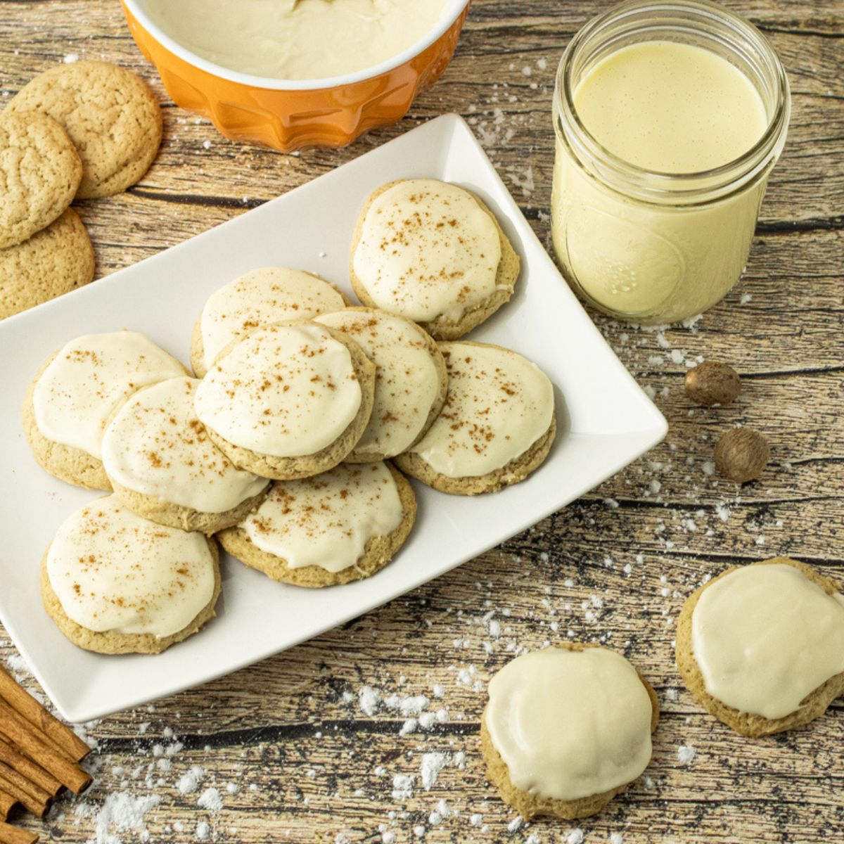 cookies made with eggnog, topped with eggnog frosting on a white plate