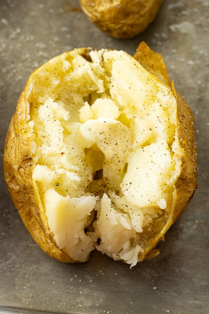 baked potato split in half with melting butter