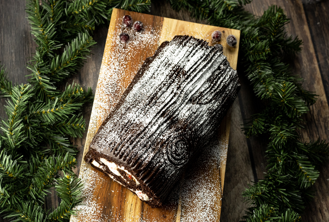 chocolate yule log cake on a wooden platter