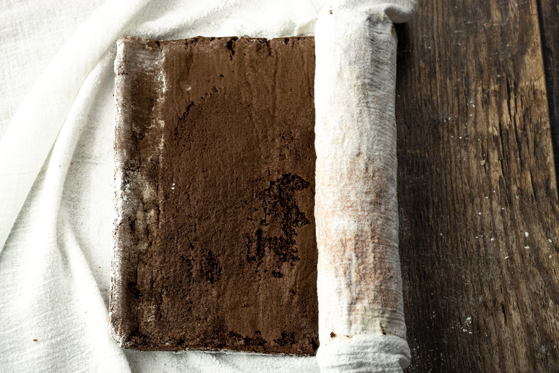 rolling a roll cake in a white kitchen towel