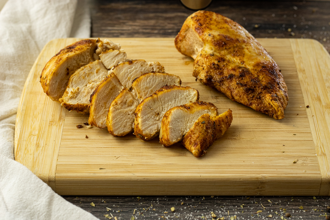 sliced chicken breast on a wooden cutting board