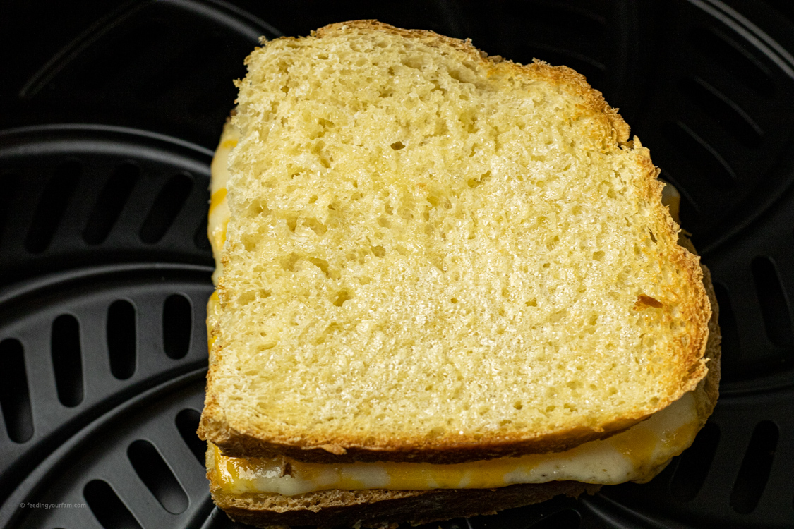 flipped cheese sandwich with cheese in an air fryer basket