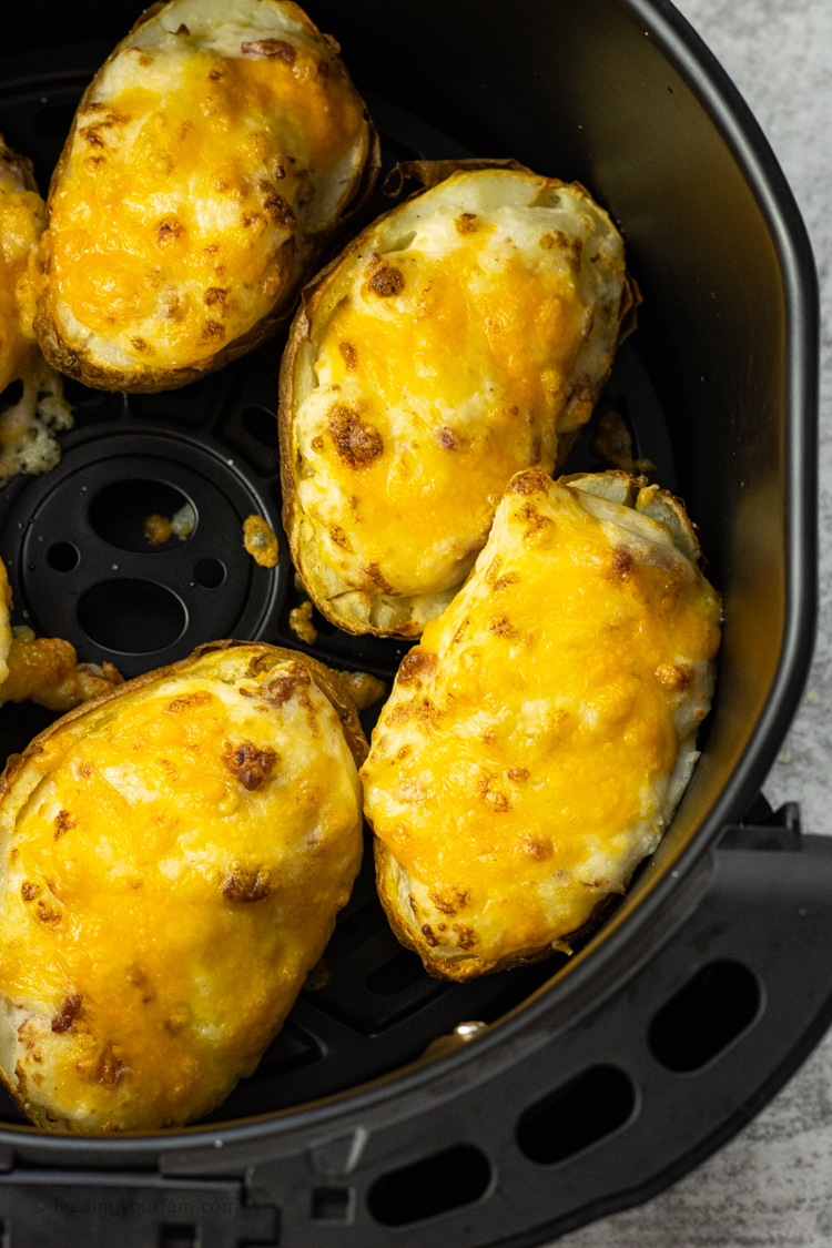 Air Fryer Twice Baked Potatoes are stuffed with sour cream mashed potatoes, bacon, cheese and topped with more cheese. All cooked in the air fryer for a simple recipe. 